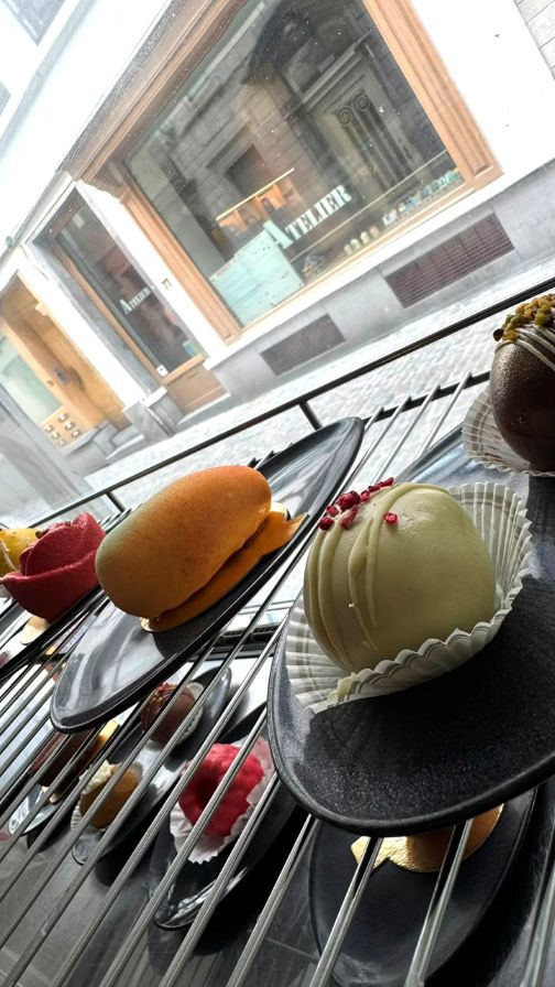 Mango-shaped and pistachio desserts on display racks overlooking the street