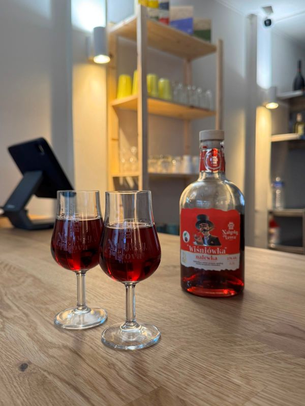 Two glasses of Wiśniówka cherry liqueur and the bottle on the wooden bar